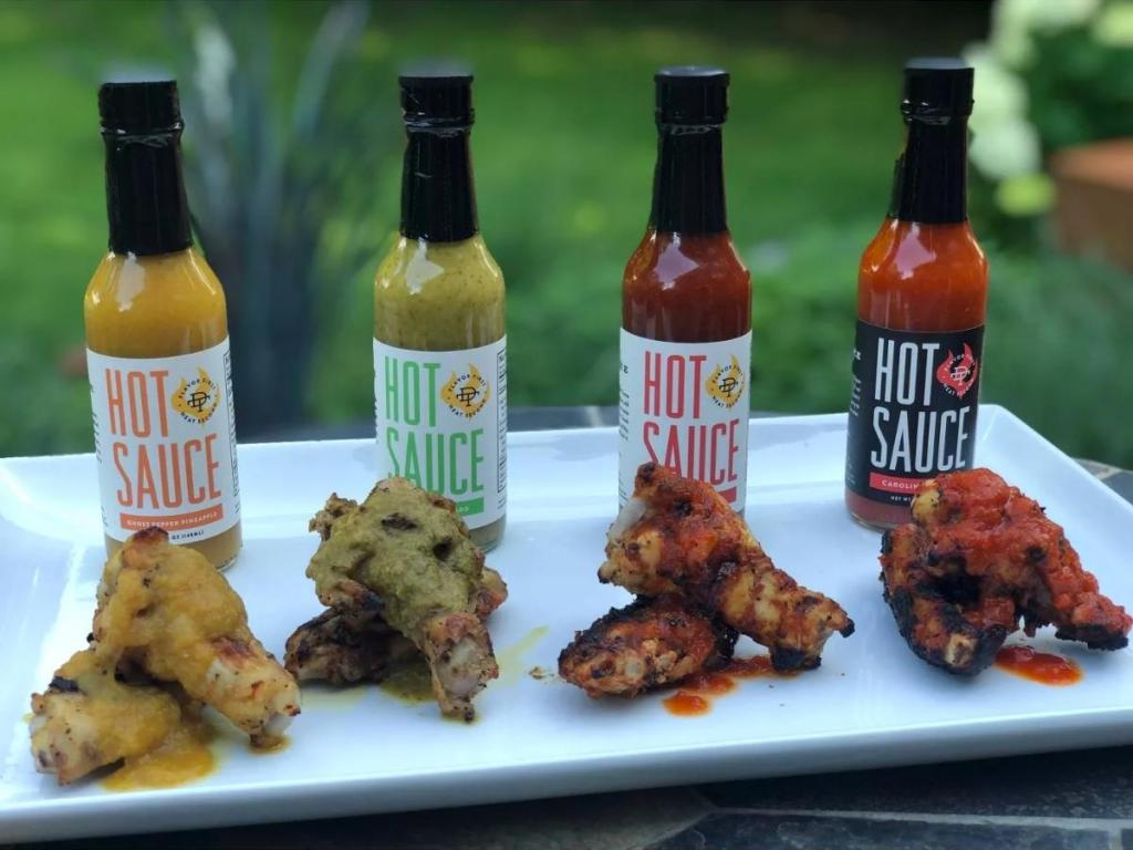 double take four different hot sauces on plate with wings