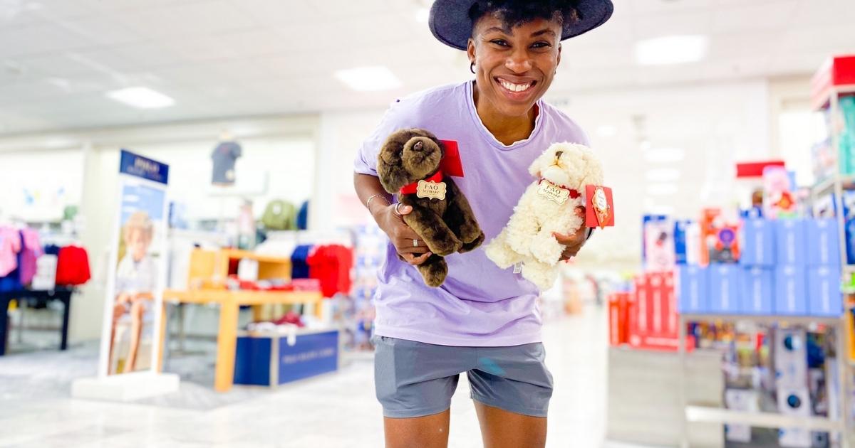 woman holding fao schwarz plush puppy dogs in store