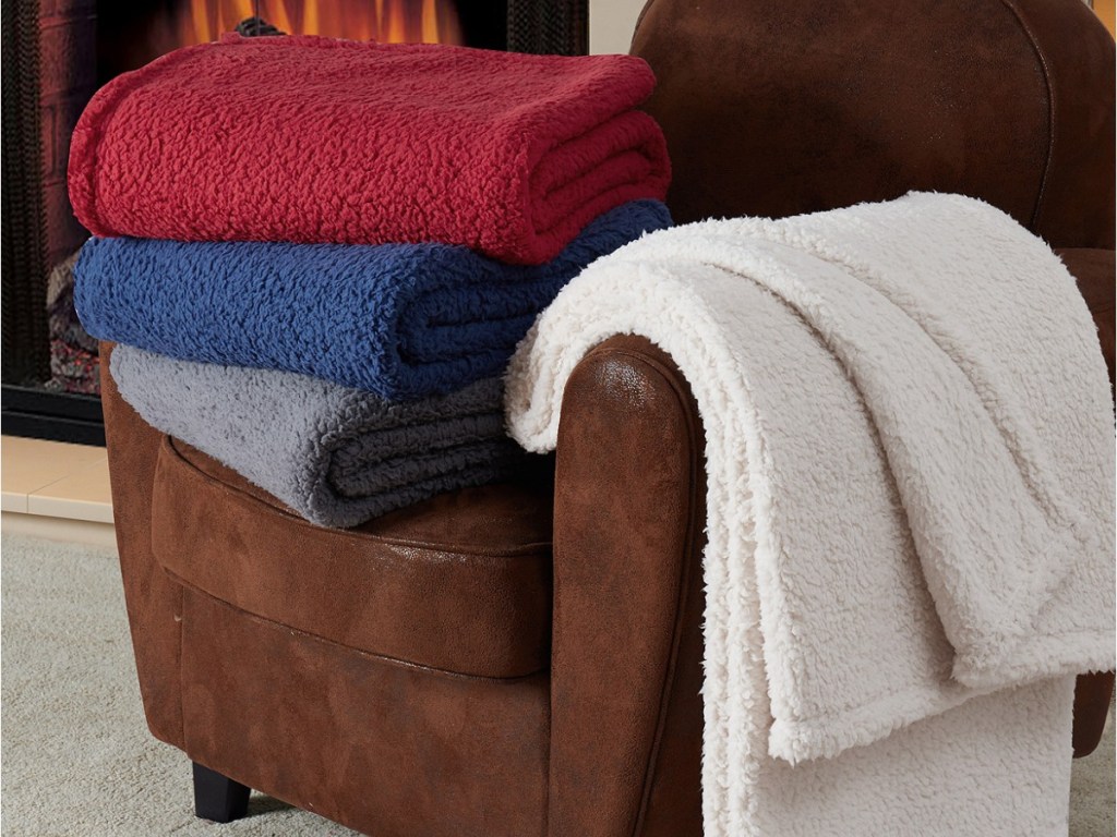red, blue, gray and white sherpa blankets on brown chair