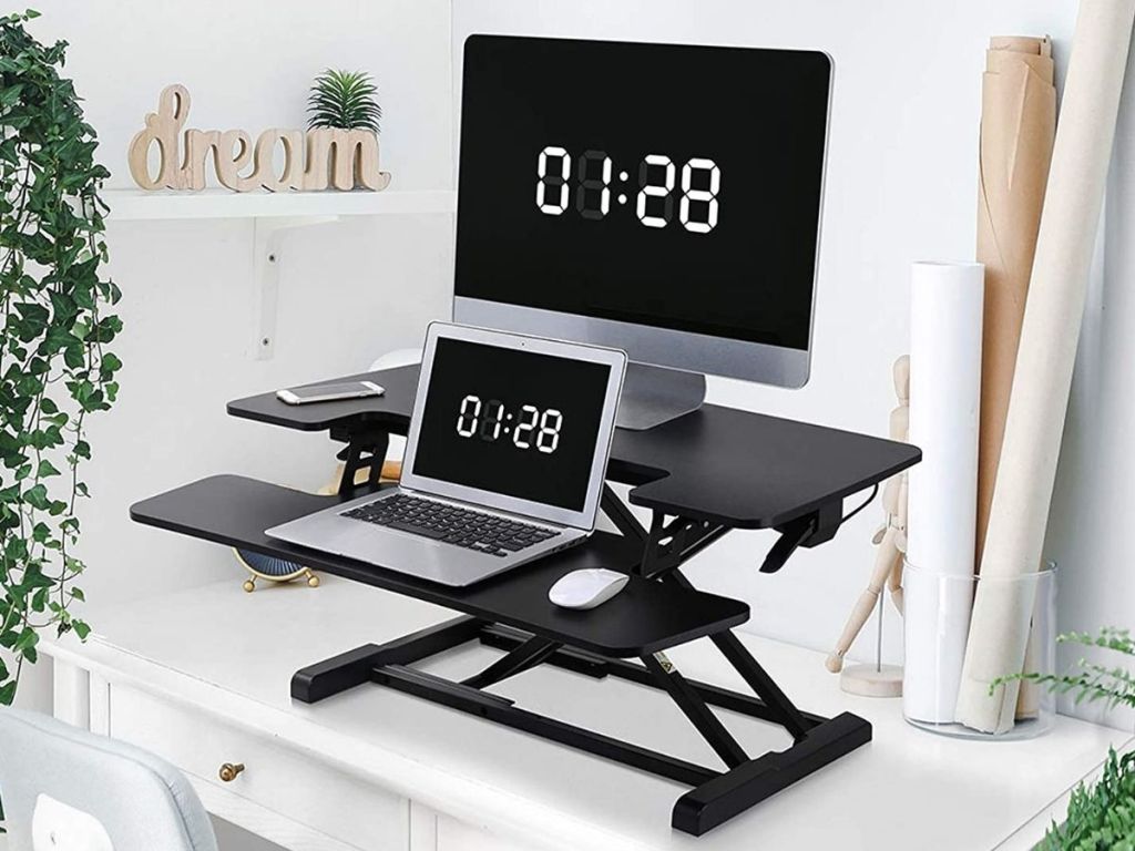 black standing desk converter with laptop and monitor