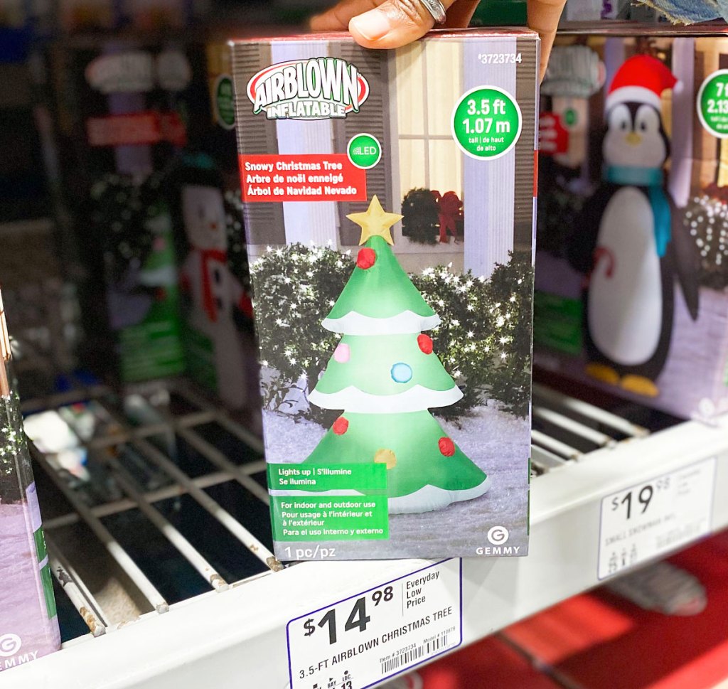 holding christmas tree inflatable on store shelf