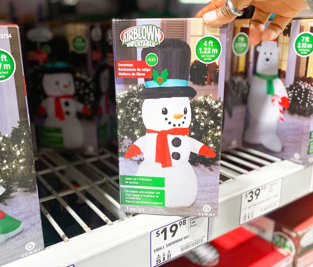 holding snowman inflatable on store shelf