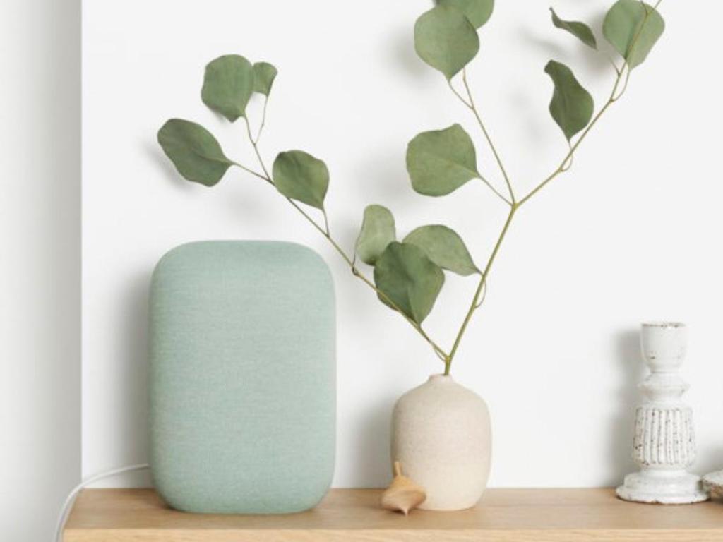 google nest audio smart speaker in sage on table with plant