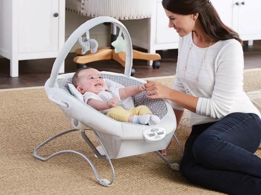 mom and baby with graco soothe 'n sway swing and portable bouncer