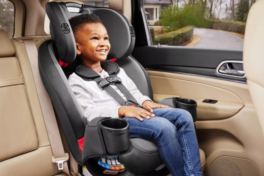 boy sitting in a black and grey car seat