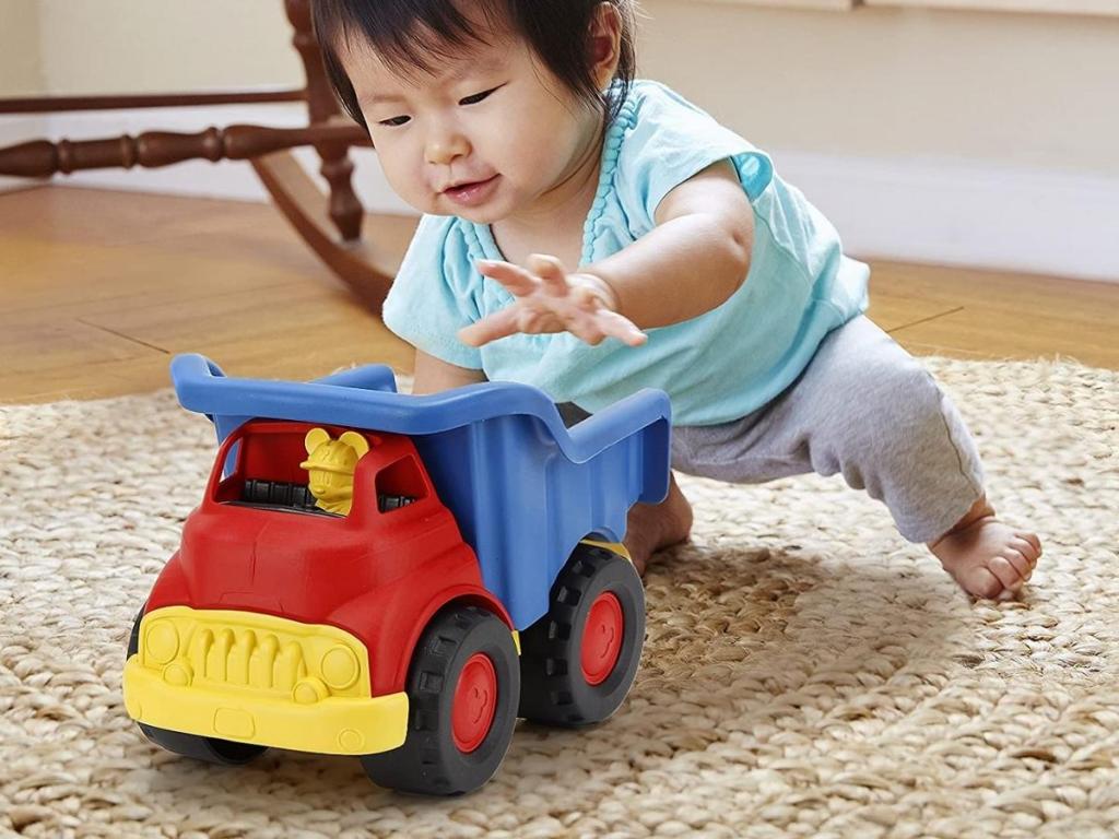young child playing with green toys mickey mouse dump truck