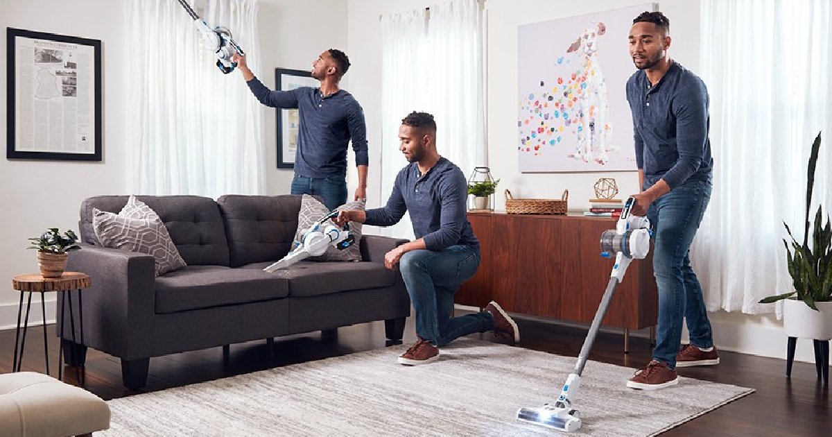 man shown in various positions of vacuuming in a living room with furniture using a hart cordless vacuum