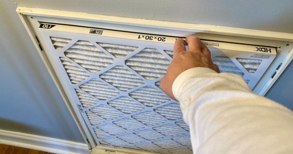 man changing hdx air filter in home household items