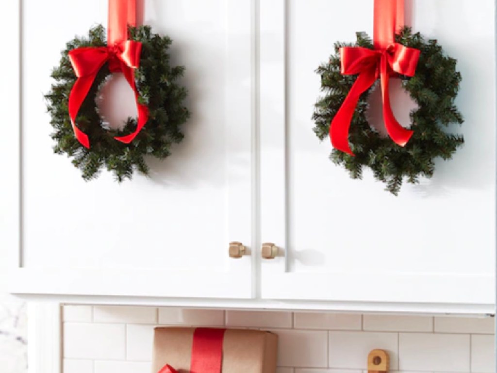 Artificial Christmas Wreaths hanging in kitchen with ribbons