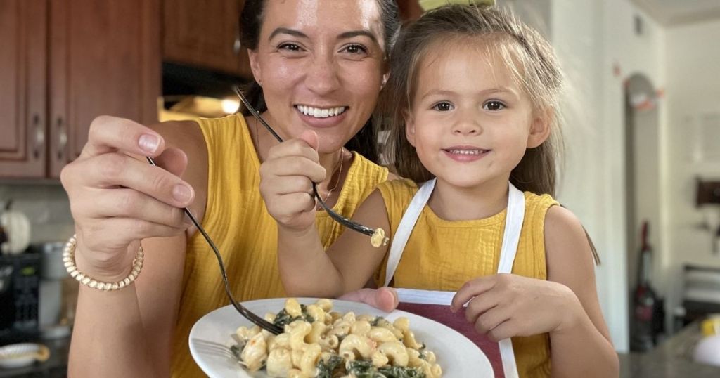 mother and daughter with a plate of pasta