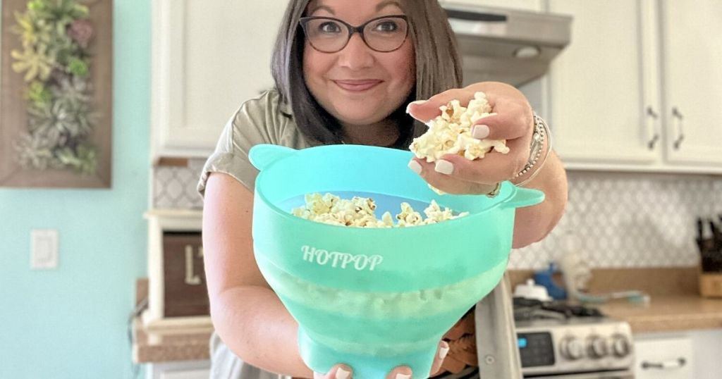 woman holding blue hotpop popcorn maker with popcorn inside