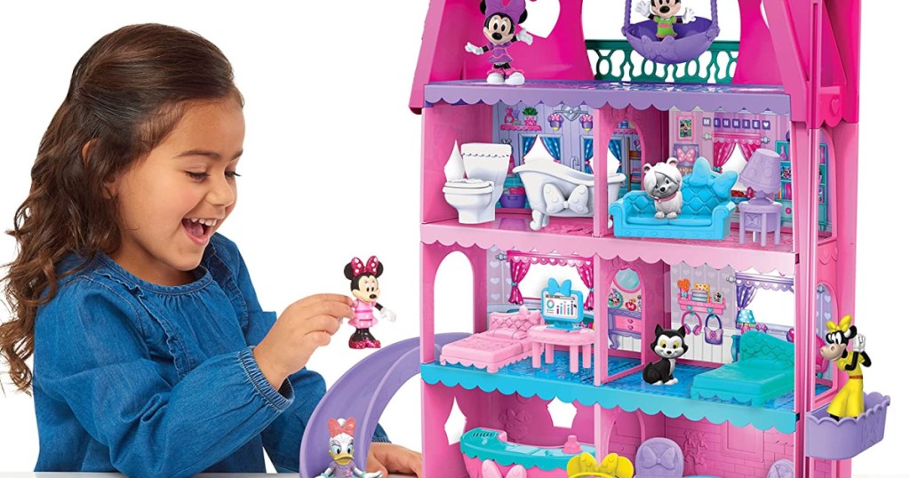 young girl playing with a minnie mouse doll house