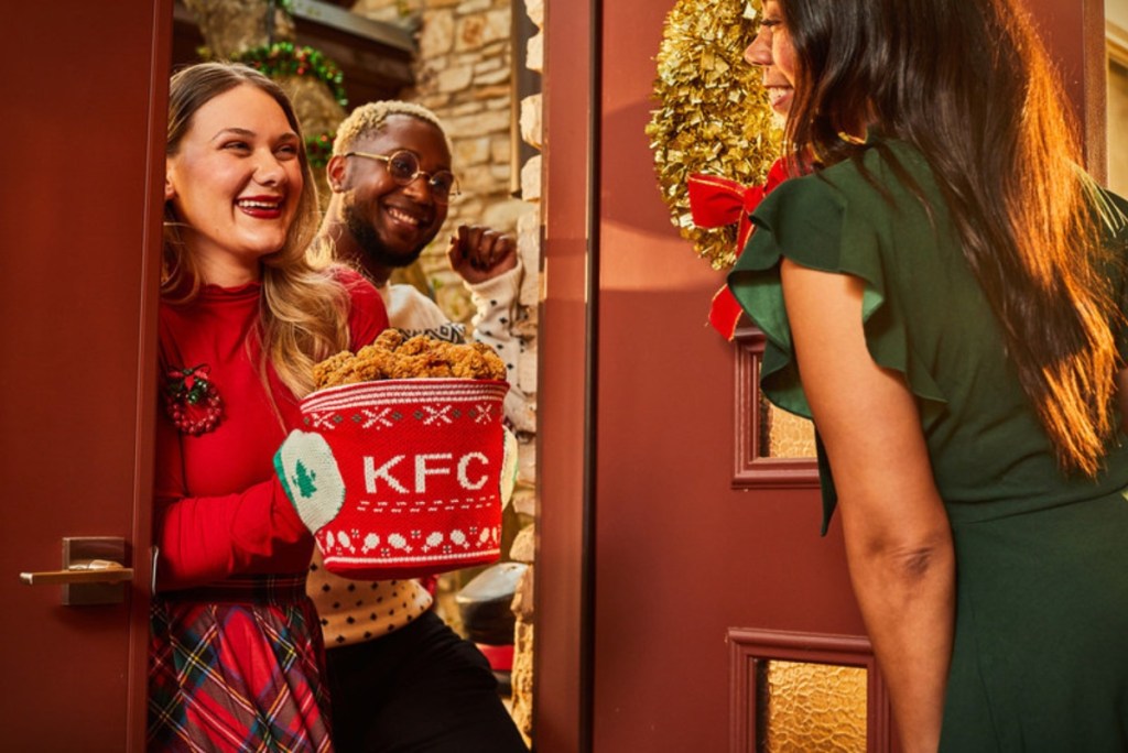 woman holding bucket of KFC wrapped in sweater