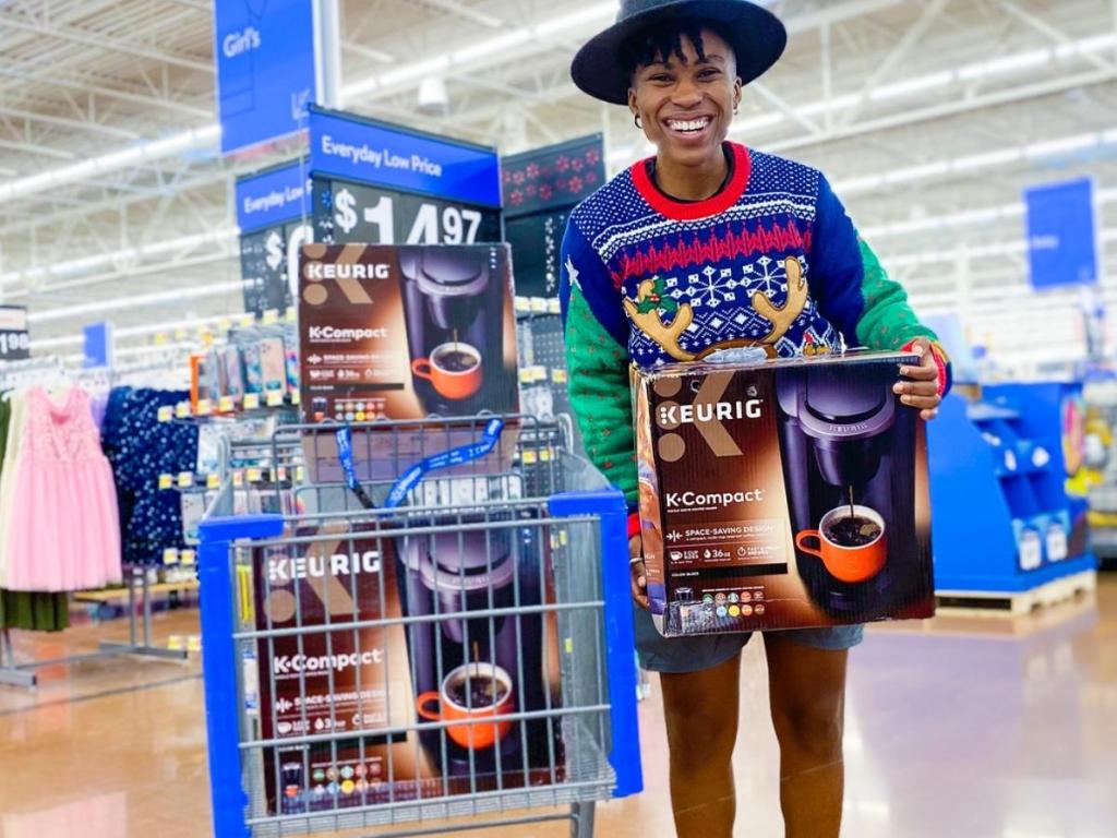 woman holding keurig k compact single serve coffee maker with other boxes in cart