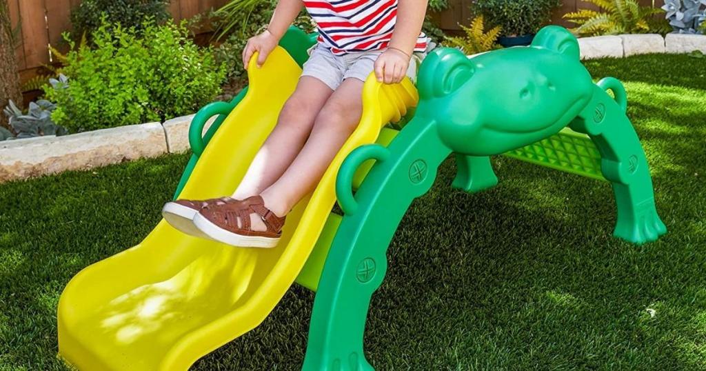 boy playing on kidkraft frog slide