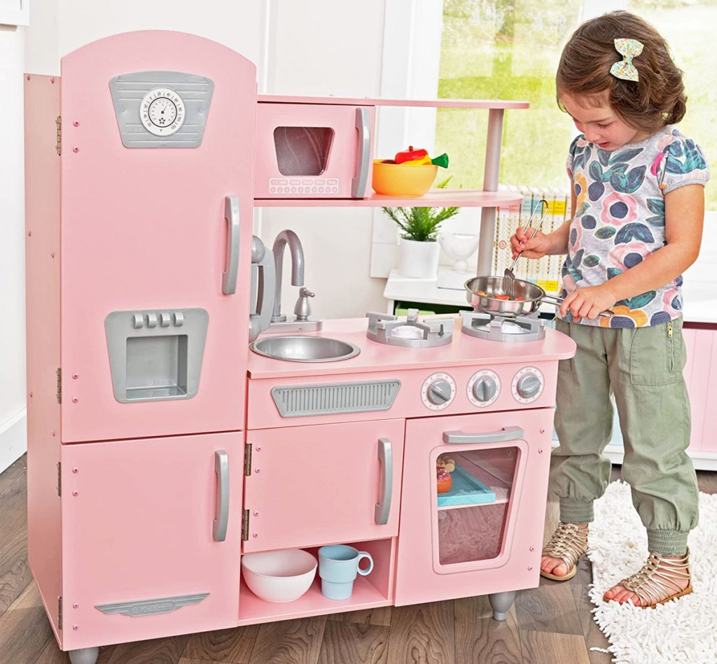 girl playing with pink kidkraft kitchen