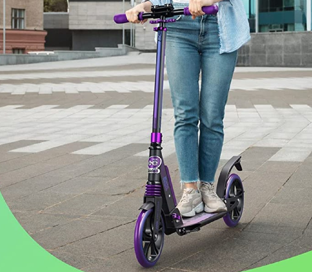 teen standing on purple scooter