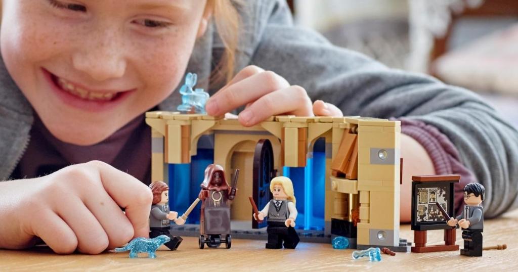 girl playing with lego harry potter room of requirement building set