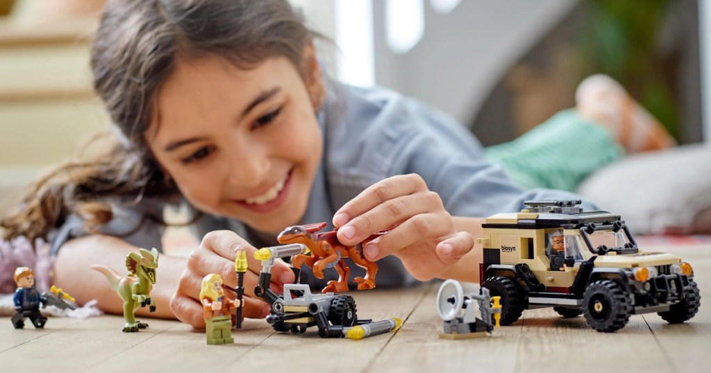 girl playing with Jurassic World Lego set