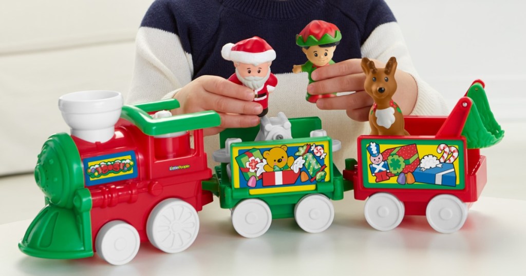 toddler playing with a holiday themed train toy