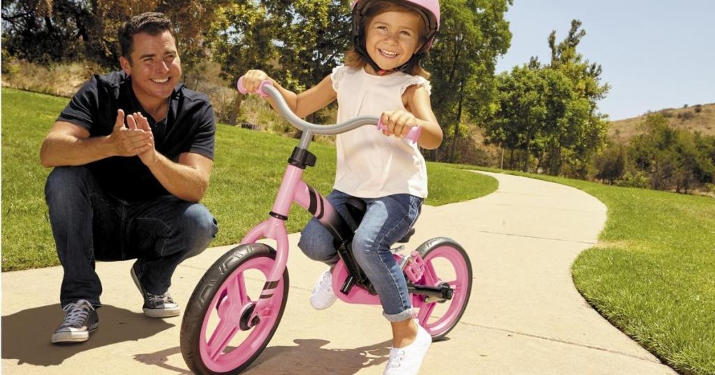 girl riding little tikes balance to pedal bike with her dad