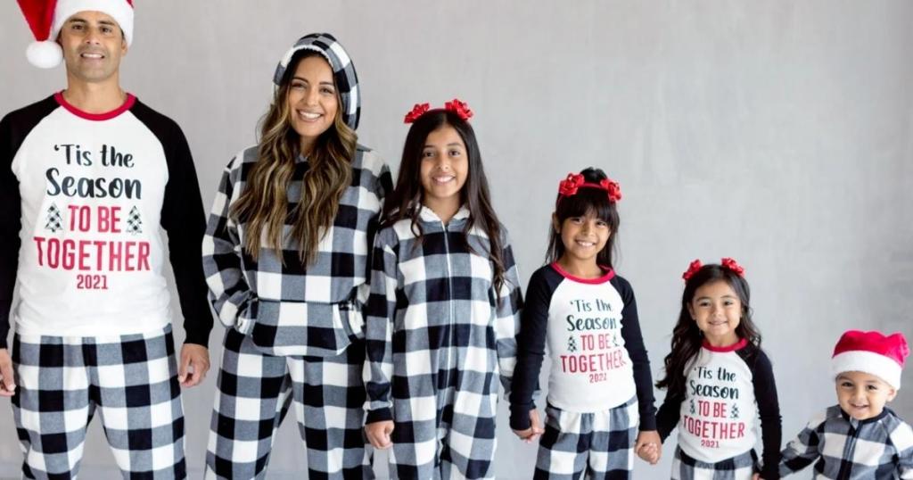 family wearing matching pajamas with black and white buffalo check