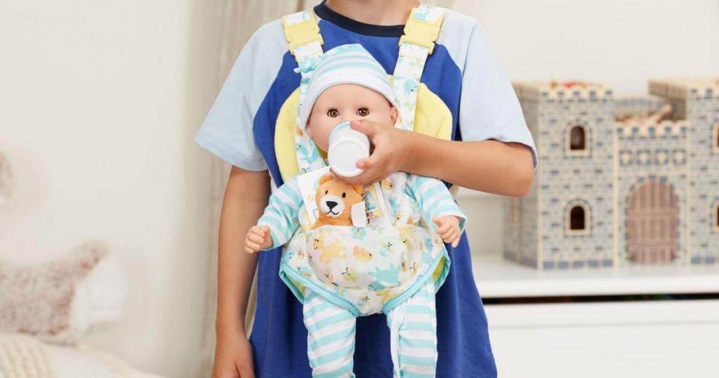 child with melissa and doug doll carrier feeding baby doll