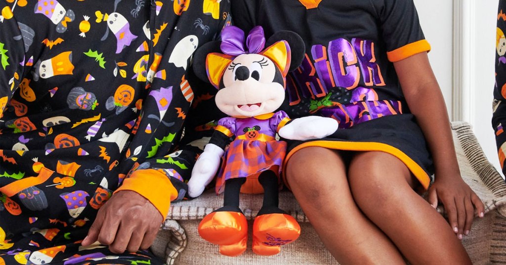kids in halloween pjs holding minnie mouse doll