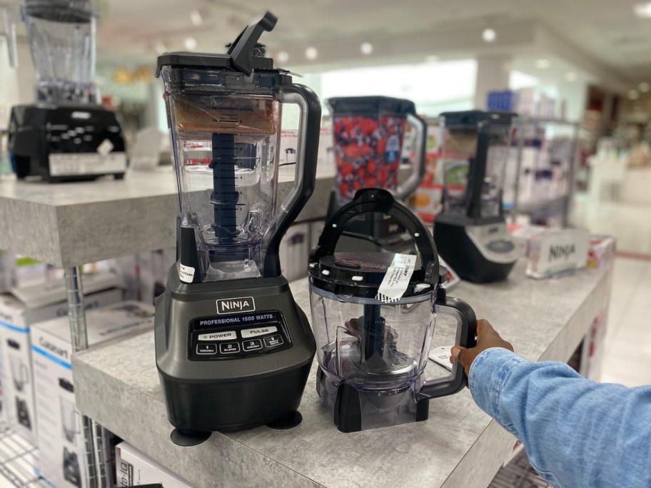 hand touching ninja blender system on display in store