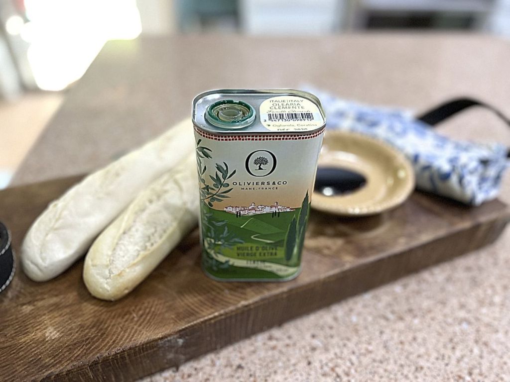 can of Olive Oil By Olivers & Co. on cutting board