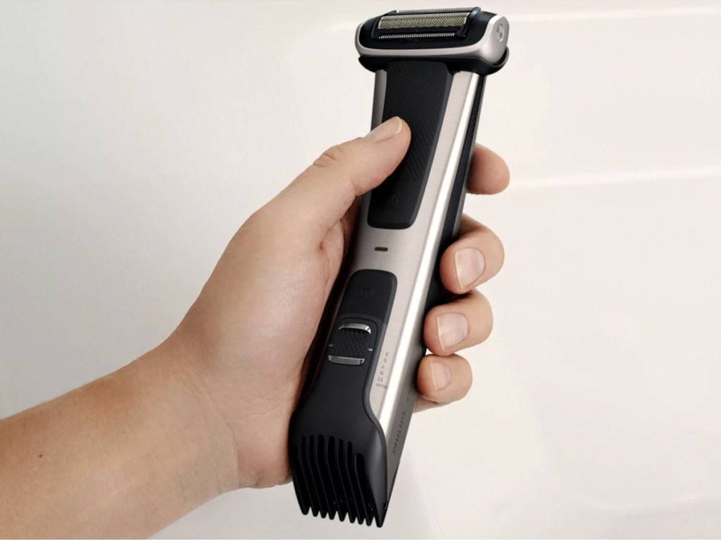 hand holding a silver and black cordless body trimmer