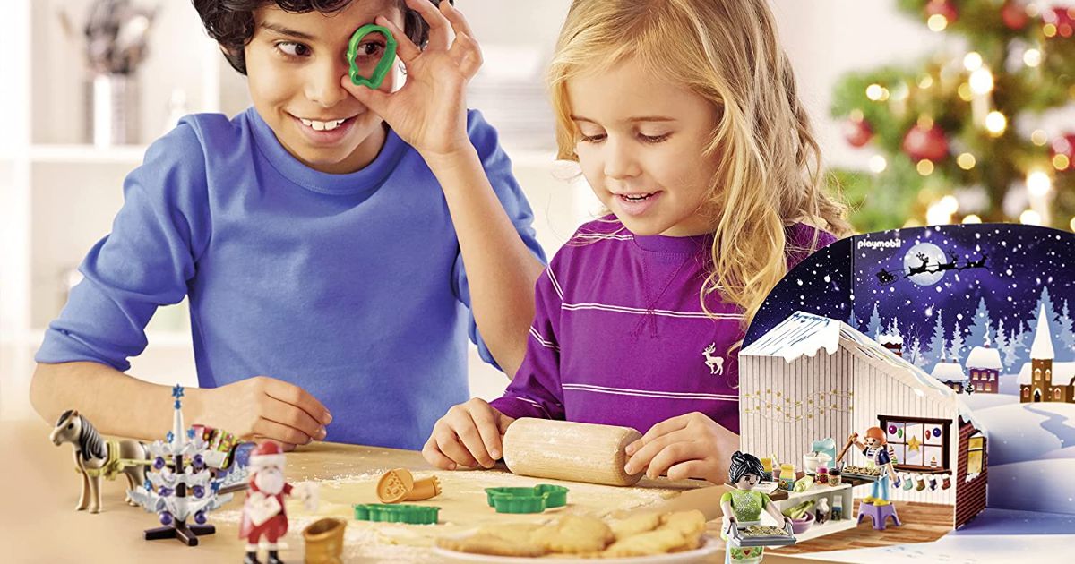 two kids playing with contents of christmas baking advent calendar