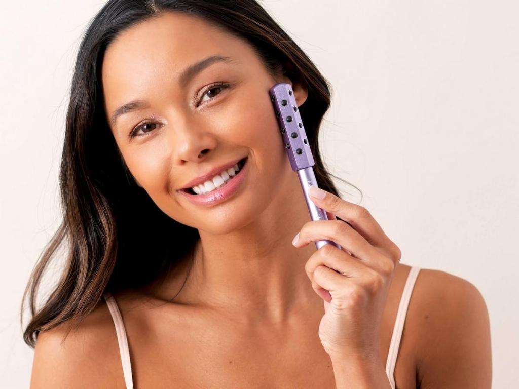 woman with plum beauty facial roller