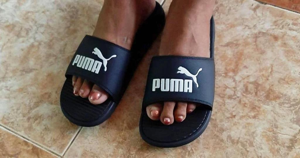 person wearing puma black slide sandals