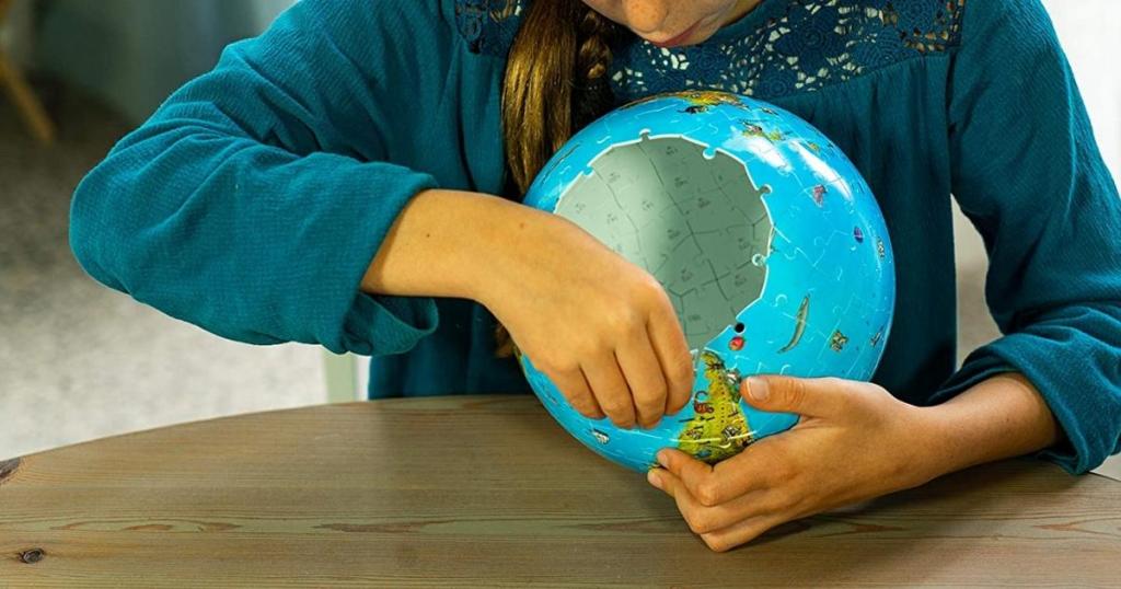 girl assembling ravensburger children's 3d globe puzzle