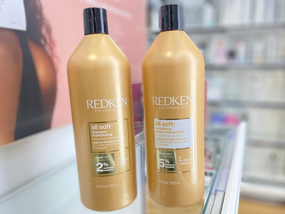 two bottles of Redken shampoo and conditioner on store shelf