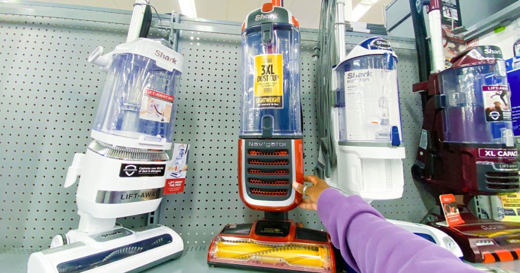 arm holding red shark vacuum in store