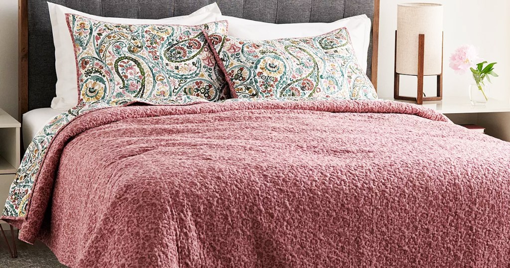 pink quilt on a bed