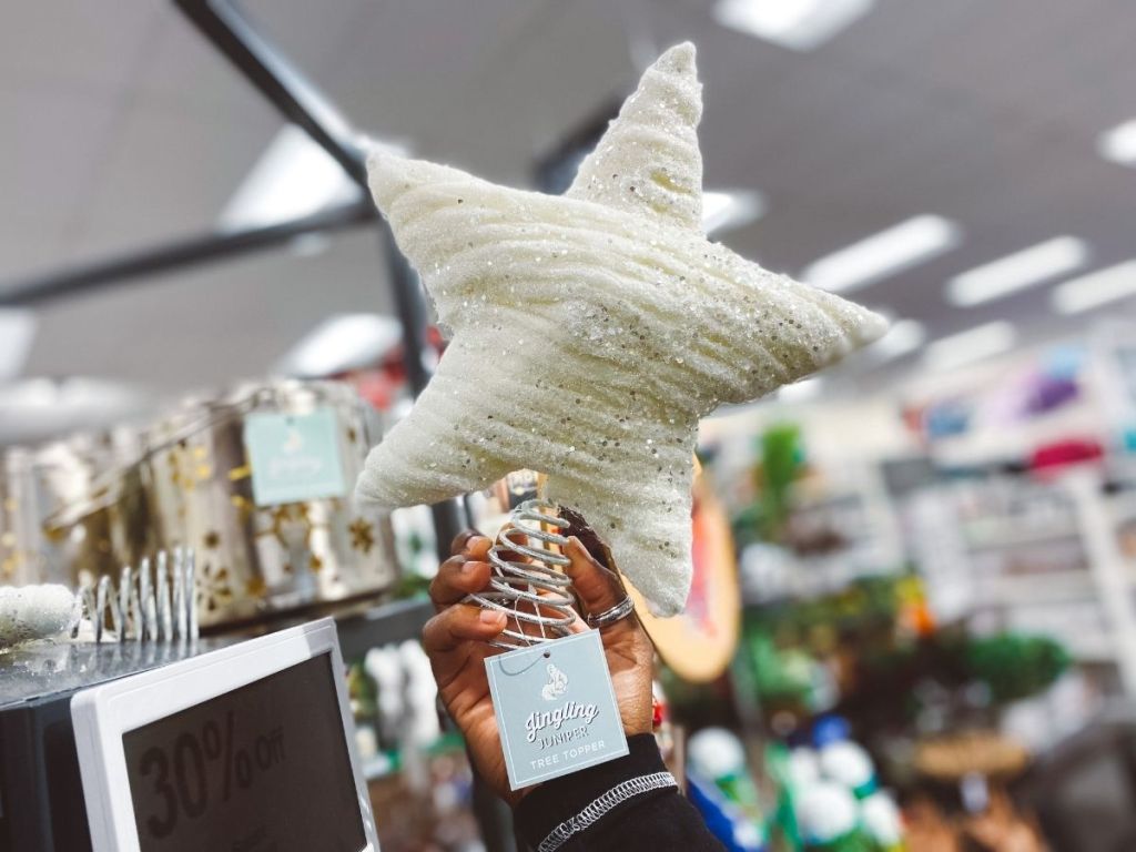 hand holding white glitter star tree topper