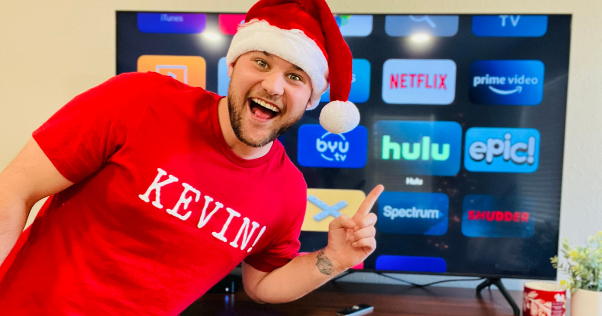 man in santa hat pointing at hulu on tv