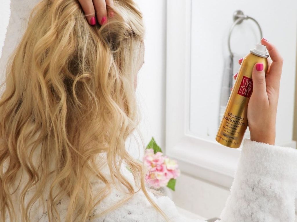 woman spraying Style Edit Blonde root spray onto hair