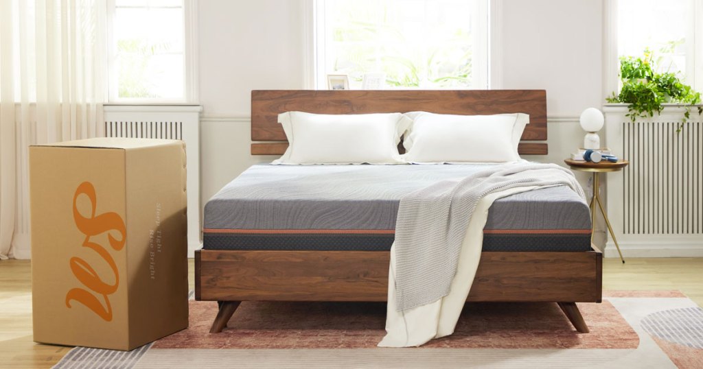 mattress on wood bed frame with shipping box next to it