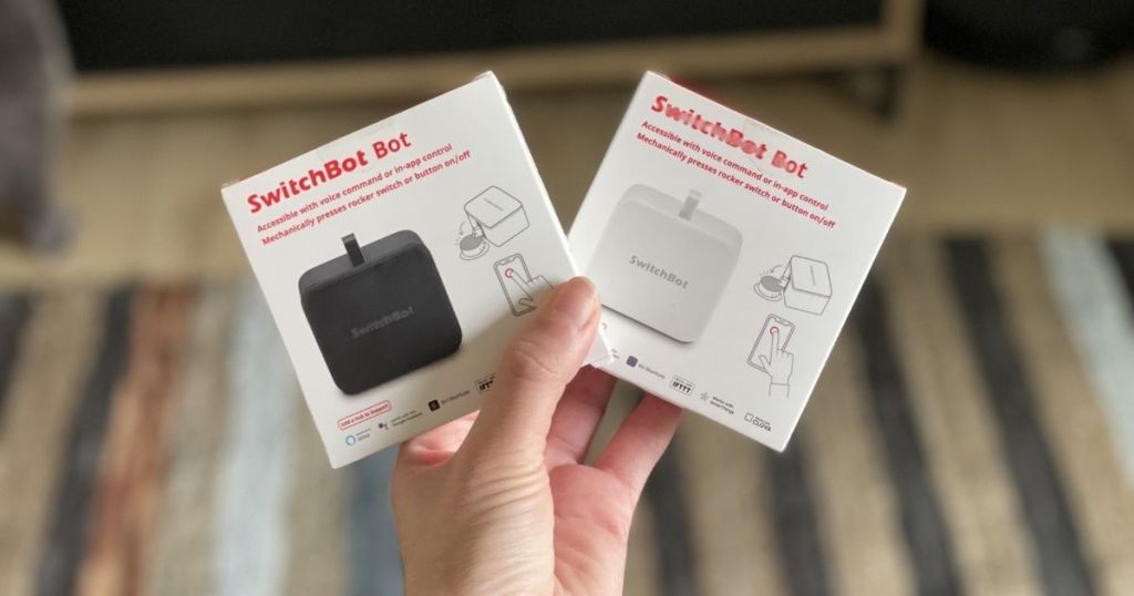 hand holding black and white SwitchBot boxes