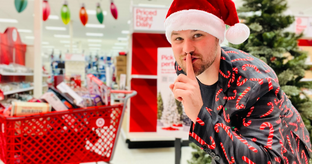 man shushing camera in store with Christmas hat and cart