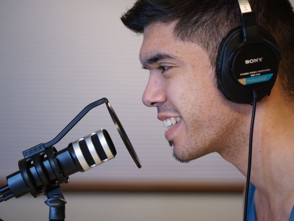 man wearing headphones speaking into microphone