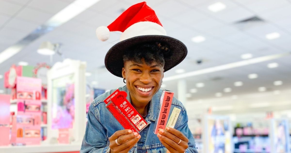 woman in santa hat holding up mascaras