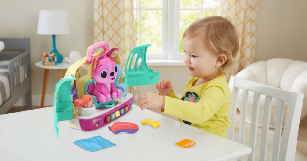 toddler at table playing with pet toy 