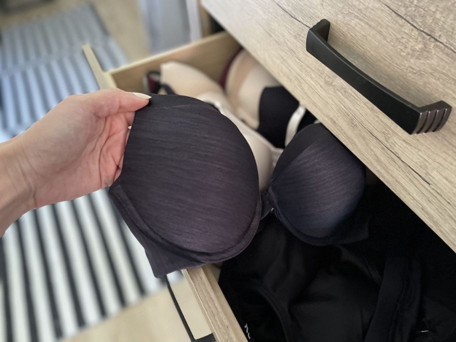 pulling a black bra out from drawer