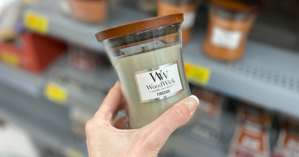 person holding up Woodwick Fireside Candle