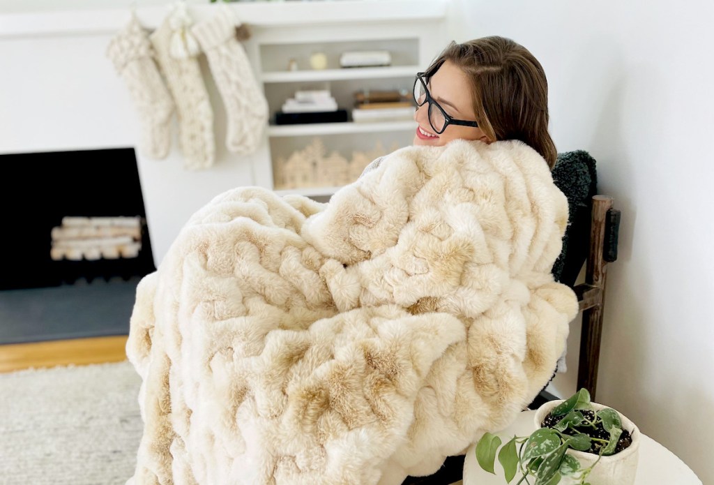 woman sitting on chair with faux fur throw blanket on lap